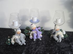 Winterfiguurtjes op een glaskaarshouder